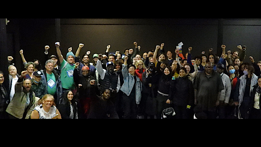 A large group of community activists pose for a group photo